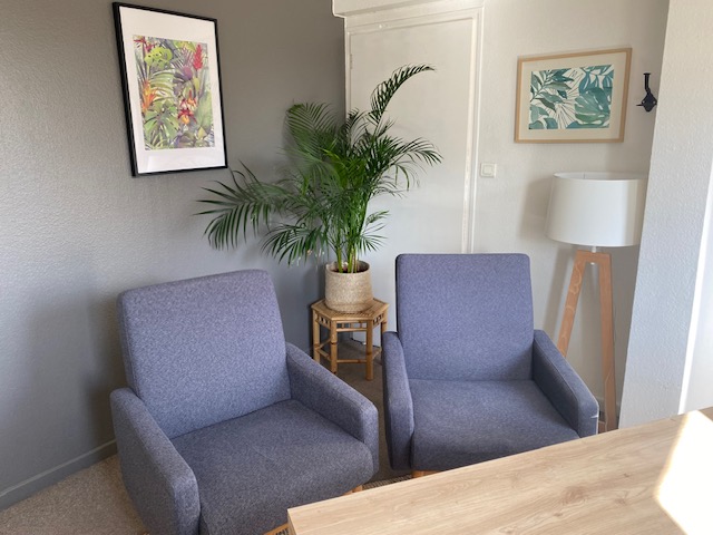 Deux fauteuils de consultation dans le cabinet face au bureau de la psychologue.